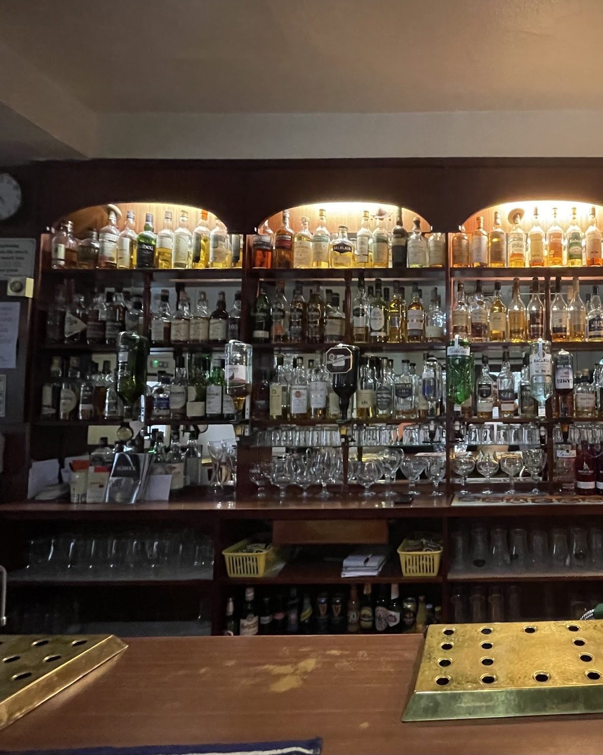 Shelves of whisky bottles lit behind the bar
